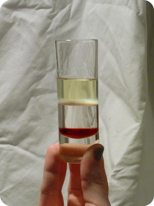 I am happy to report the successful conclusion of home experiments directed at meeting the well-known need, too long unmet, for a potable facsimile of a blood sample separated over a Ficoll gradient. As a service, I provide the protocol below. / First, mix each master mix thoroughly:. / Layer 1: 1:1 mix Chambord:grenadine syrup. / Layer 2: 1:1 mix Hungarian apricot brandy (barack palinka):simple syrup. Any clear, colorless 40% alcohol spirit may be substituted for the apricot brandy, although the taste will change, surely for the worse. Simple syrup is made by dissolving 1 cup sugar in 1 cup boiling water, and cooling. / Layer 3: 2:1 mix vodka:limoncello. The following volumes are then carefully pipetted, in order, into a tall shot glass. (In this singular instance, mouth pipetting is an acceptable risk.):. / Layer 1: 5 mL. / Layer 2: 15 mL. / Layer 3: 15 mL At this point, the investigator will have a red layer at bottom (red blood cells), a clear, colorless middle layer (the Ficoll), and a straw-colored top layer (the plasma). To produce the white blood cell layer, introduce a pipette containing 1 mL skim milk into the interface between layers 2 and 3. Slowly dispense the skim milk, distributing throughout the layer. The 3 layers may be prepared first and the skim milk added right before serving, as the skim milk layer may diffuse over time. / The result, shown in the figure, is sweet and fruity, may be chilled if desired, and is best enjoyed with a hematologist.