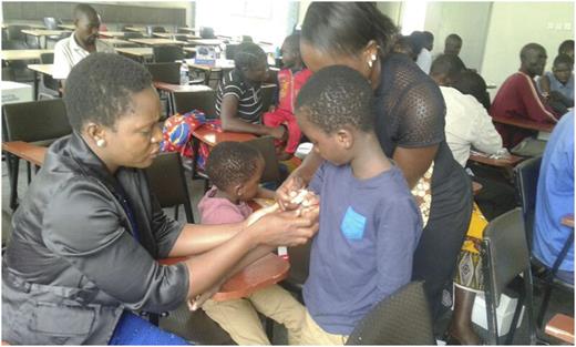 Figure 6. A parent placing a butterfly needle on her son to infuse factor VIII.