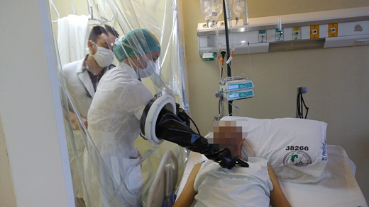 HEPA-filtered room with positive pressure where patient is examined through a plastic separator.