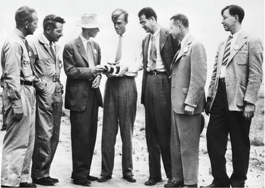 "Seven Atom Bomb Scientists Look over a Roengenometer at the Site of the Test Atom Bomb